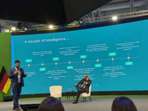 Alexandre Pigatti da Vale apresenta a linha do tempo A decade of intelligence na Hannover Messe 2026 mostrando a evolução da estratégia de IA da empresa de 2017 a 2025